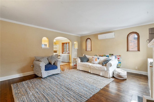 living area featuring ornamental molding, a wall mounted AC, wood finished floors, arched walkways, and baseboards