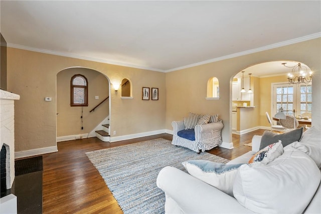 living area with baseboards, arched walkways, and wood finished floors