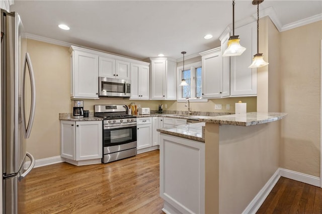 kitchen featuring a peninsula, stainless steel appliances, light wood-style floors, white cabinetry, and crown molding