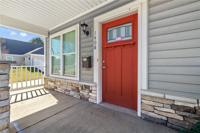 entrance to property featuring stone siding and covered porch