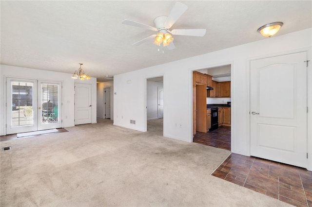 unfurnished living room with carpet flooring, ceiling fan with notable chandelier, and visible vents