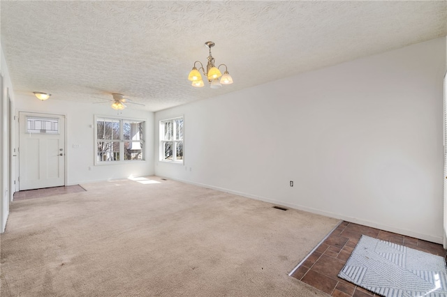 spare room featuring visible vents, baseboards, carpet, and a textured ceiling