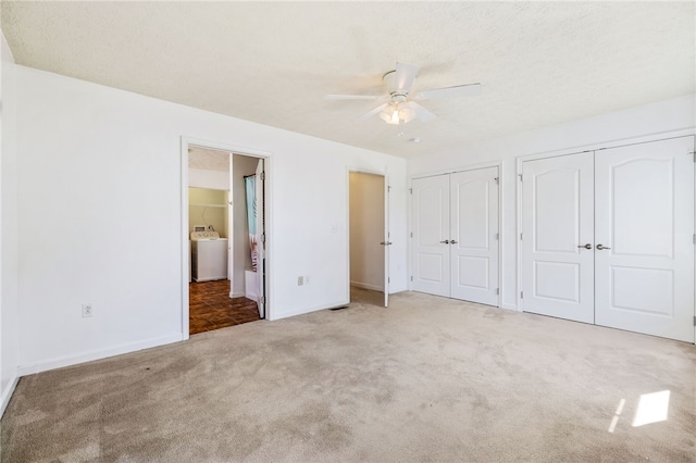 unfurnished bedroom featuring baseboards, multiple closets, carpet flooring, washer / dryer, and ensuite bath