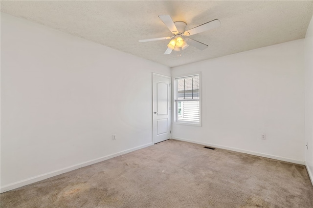 spare room with carpet flooring, a ceiling fan, baseboards, and a textured ceiling