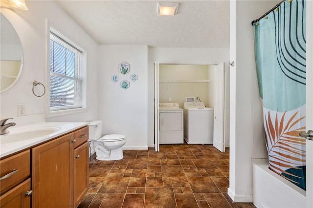 full bathroom featuring toilet, independent washer and dryer, a textured ceiling, baseboards, and vanity