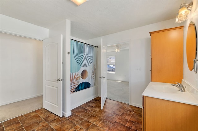 bathroom featuring baseboards, shower / tub combo, a textured ceiling, and vanity