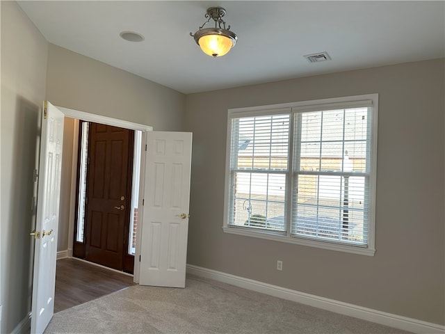 unfurnished bedroom featuring visible vents, carpet, and baseboards