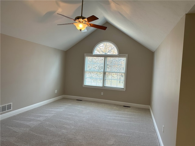 unfurnished room with visible vents, baseboards, light colored carpet, and lofted ceiling