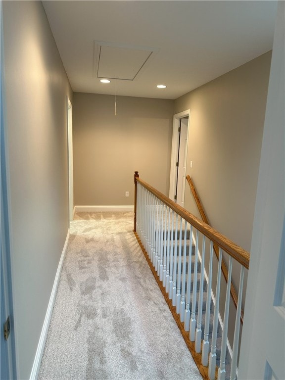 hallway with baseboards, attic access, recessed lighting, carpet flooring, and an upstairs landing