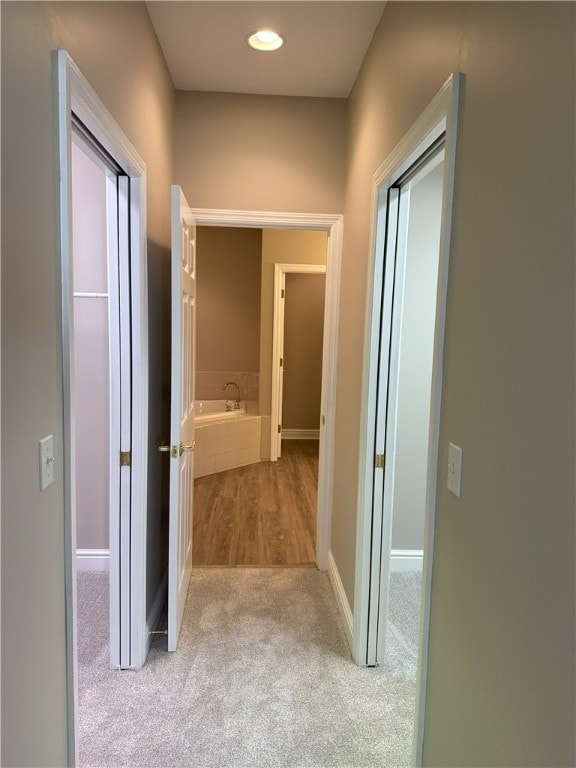 corridor with baseboards and carpet floors