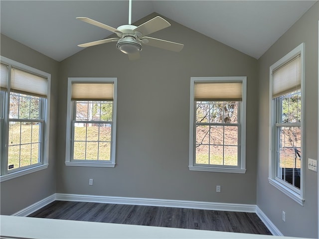 unfurnished room with dark wood-style floors, baseboards, a wealth of natural light, and vaulted ceiling