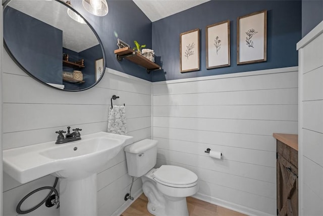 bathroom featuring a wainscoted wall and toilet