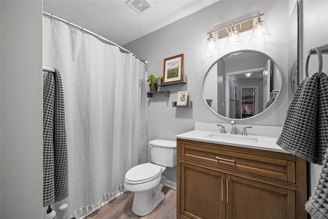 full bathroom featuring vanity, a shower with curtain, wood finished floors, visible vents, and toilet