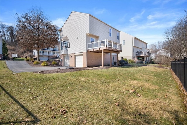 back of property with a garage, driveway, a yard, and fence