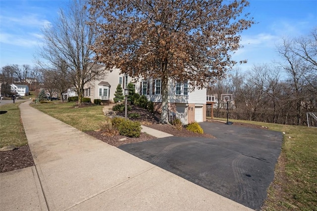 view of front of house with a front yard, an attached garage, and driveway