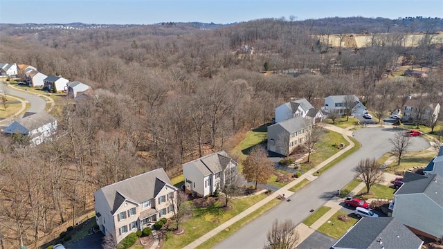 drone / aerial view featuring a residential view and a wooded view