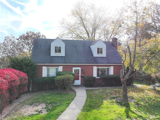 cape cod house with a front lawn, brick siding, and a chimney