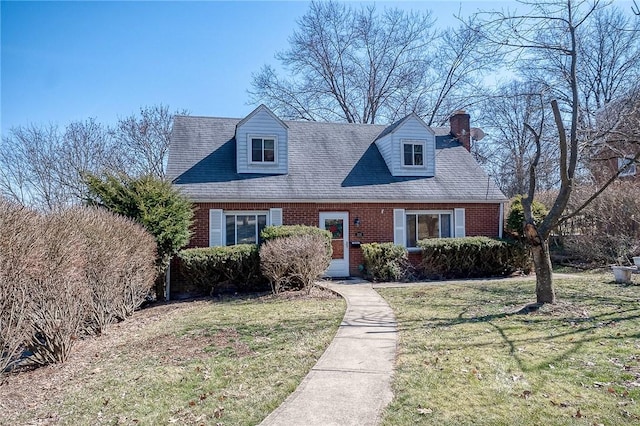 cape cod-style house featuring brick siding and a front lawn