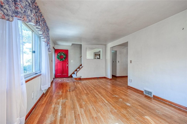 interior space with visible vents, baseboards, light wood-style flooring, and stairway