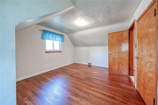 bonus room featuring visible vents, baseboards, lofted ceiling, and wood finished floors