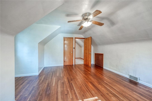 additional living space with wood finished floors, visible vents, baseboards, lofted ceiling, and ceiling fan