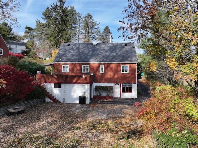 rear view of house with brick siding, central air condition unit, and stairs