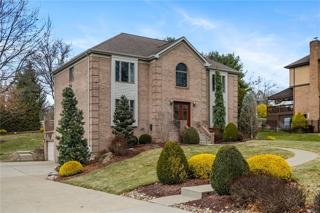 view of front of home with fence, concrete driveway, a front yard, a garage, and brick siding