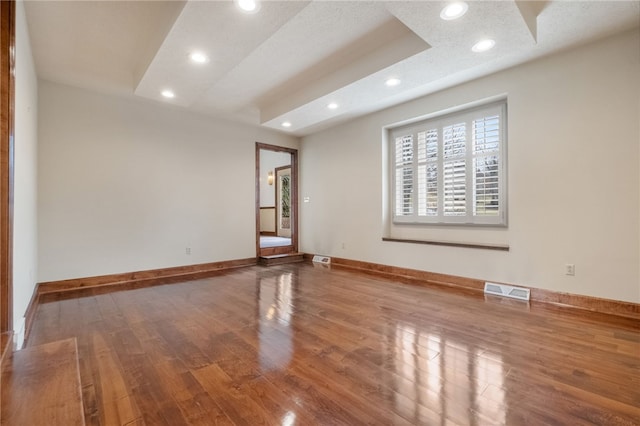 unfurnished room with recessed lighting, visible vents, baseboards, and wood finished floors