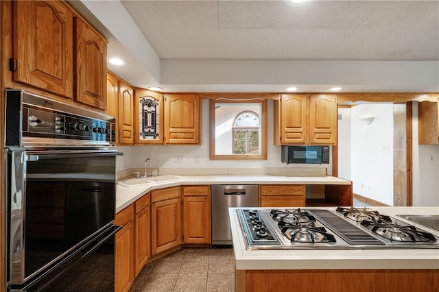 kitchen with granite finish floor, recessed lighting, a sink, black appliances, and light countertops