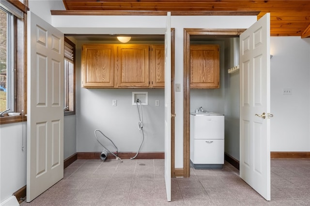 laundry room with a sink, baseboards, cabinet space, and hookup for a washing machine