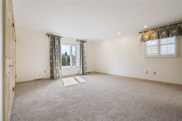 carpeted spare room featuring recessed lighting, visible vents, and baseboards