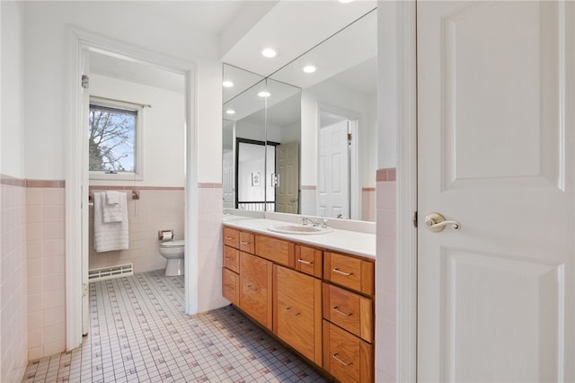 bathroom with toilet, recessed lighting, tile walls, tile patterned flooring, and vanity