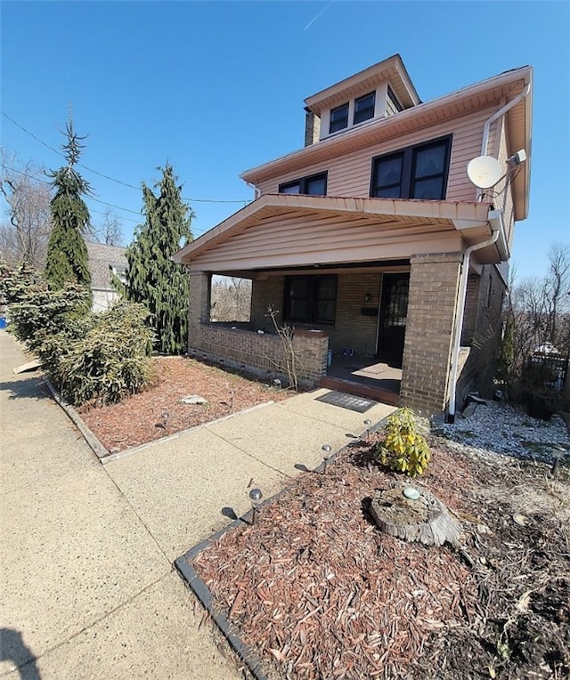 view of front of property with covered porch and brick siding