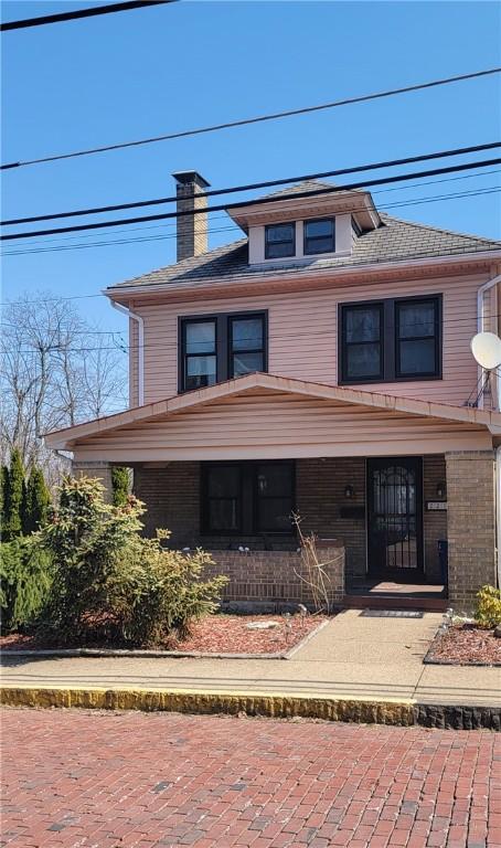 american foursquare style home featuring a chimney