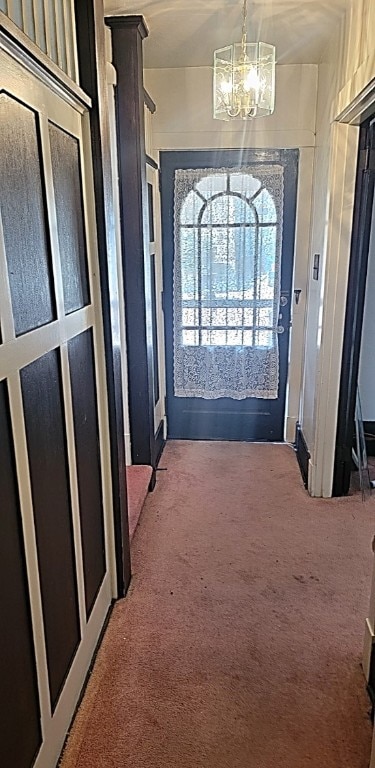 entryway featuring a notable chandelier and carpet