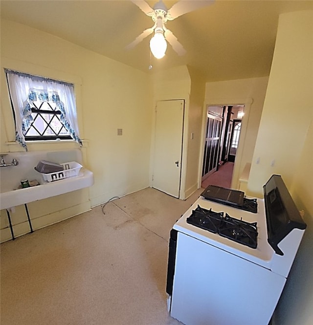 kitchen featuring light carpet, white range with gas cooktop, and a ceiling fan