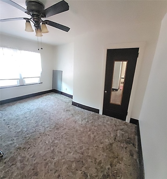 spare room with carpet flooring, a ceiling fan, and baseboards