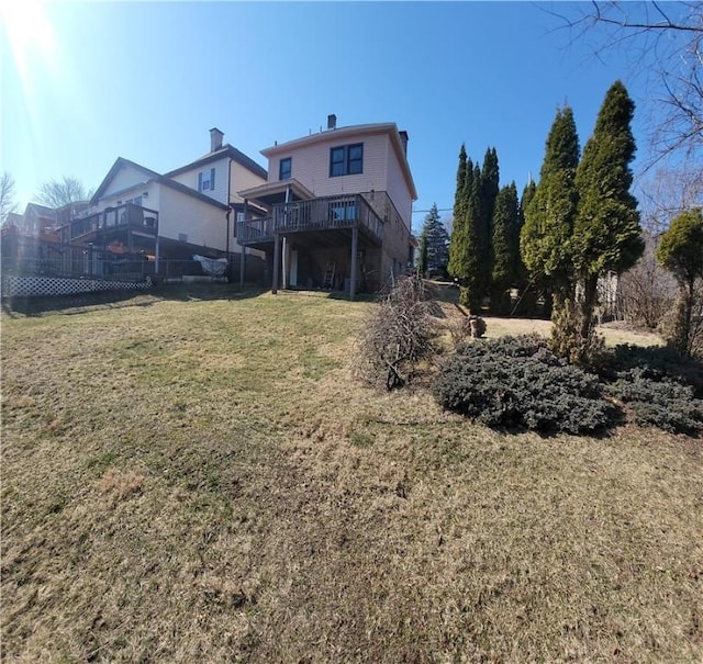 back of property with stairs, a lawn, and a wooden deck