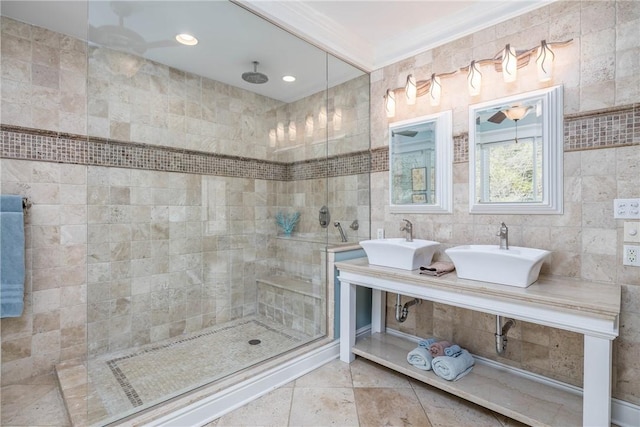 bathroom featuring a sink, tiled shower, tile walls, and tile patterned floors