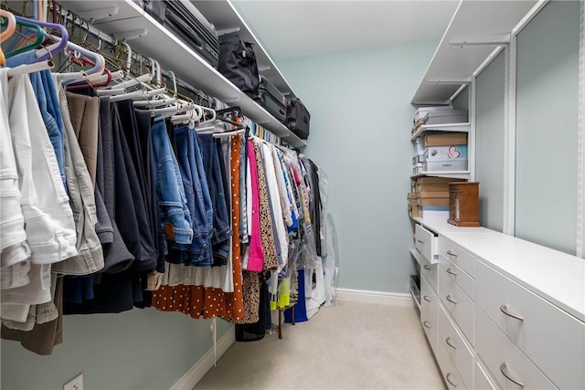 walk in closet featuring light carpet