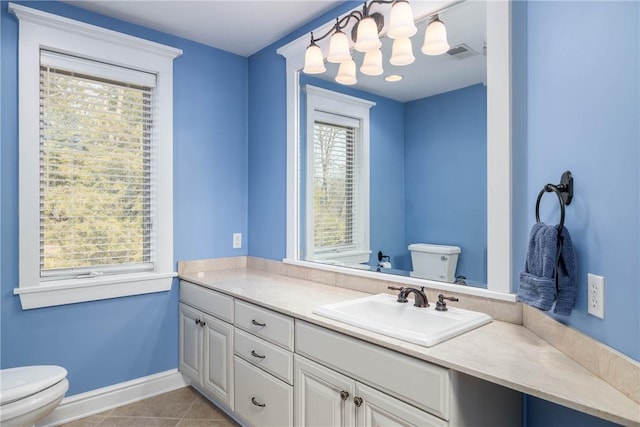 bathroom featuring vanity, baseboards, visible vents, tile patterned flooring, and toilet