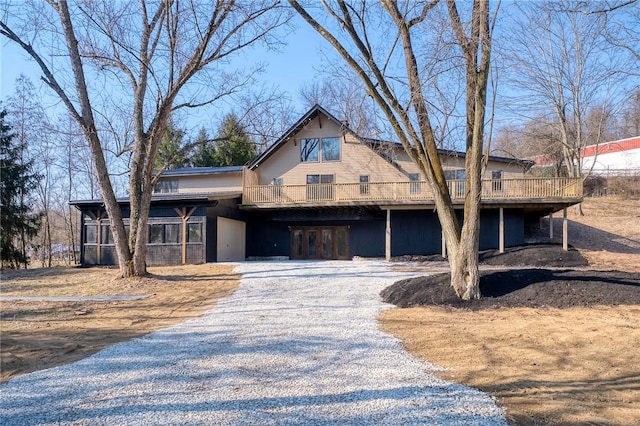 view of front of property featuring gravel driveway and a wooden deck