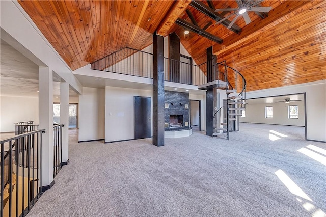 unfurnished living room with high vaulted ceiling, a fireplace, wood ceiling, and carpet