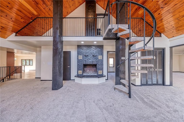 unfurnished living room with wooden ceiling, a fireplace, carpet floors, and high vaulted ceiling