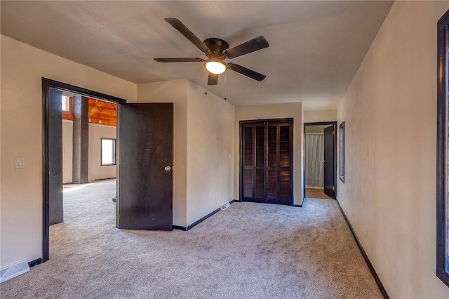 unfurnished bedroom with a ceiling fan, carpet flooring, baseboards, and visible vents