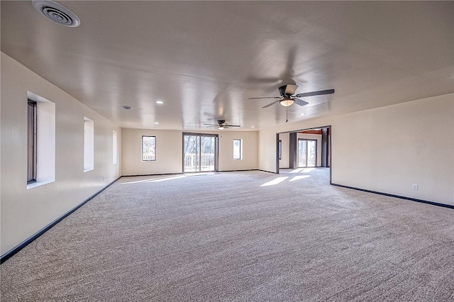 empty room with visible vents, baseboards, carpet, and ceiling fan