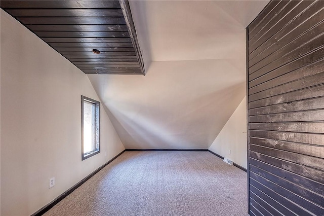 interior space featuring vaulted ceiling, baseboards, and carpet floors