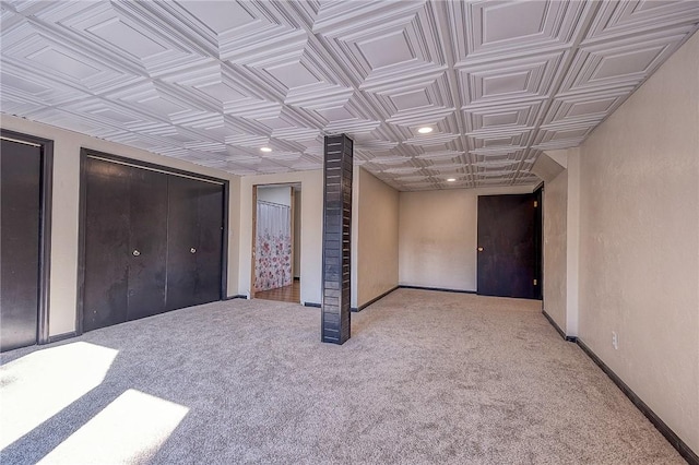 interior space featuring carpet flooring, recessed lighting, baseboards, and an ornate ceiling