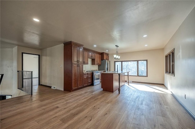 kitchen with a chandelier, light countertops, wood finished floors, hanging light fixtures, and stainless steel appliances