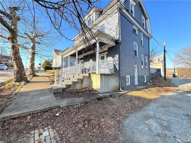 view of side of property with covered porch and a chimney